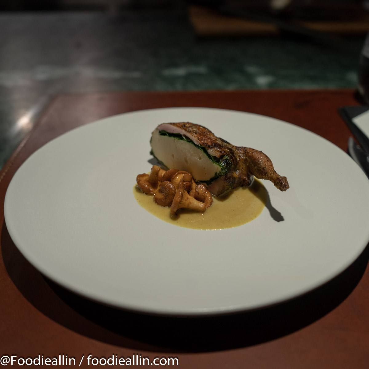 Roasted quail stuffed with quail mousse and spinach, served with girolles and curry.